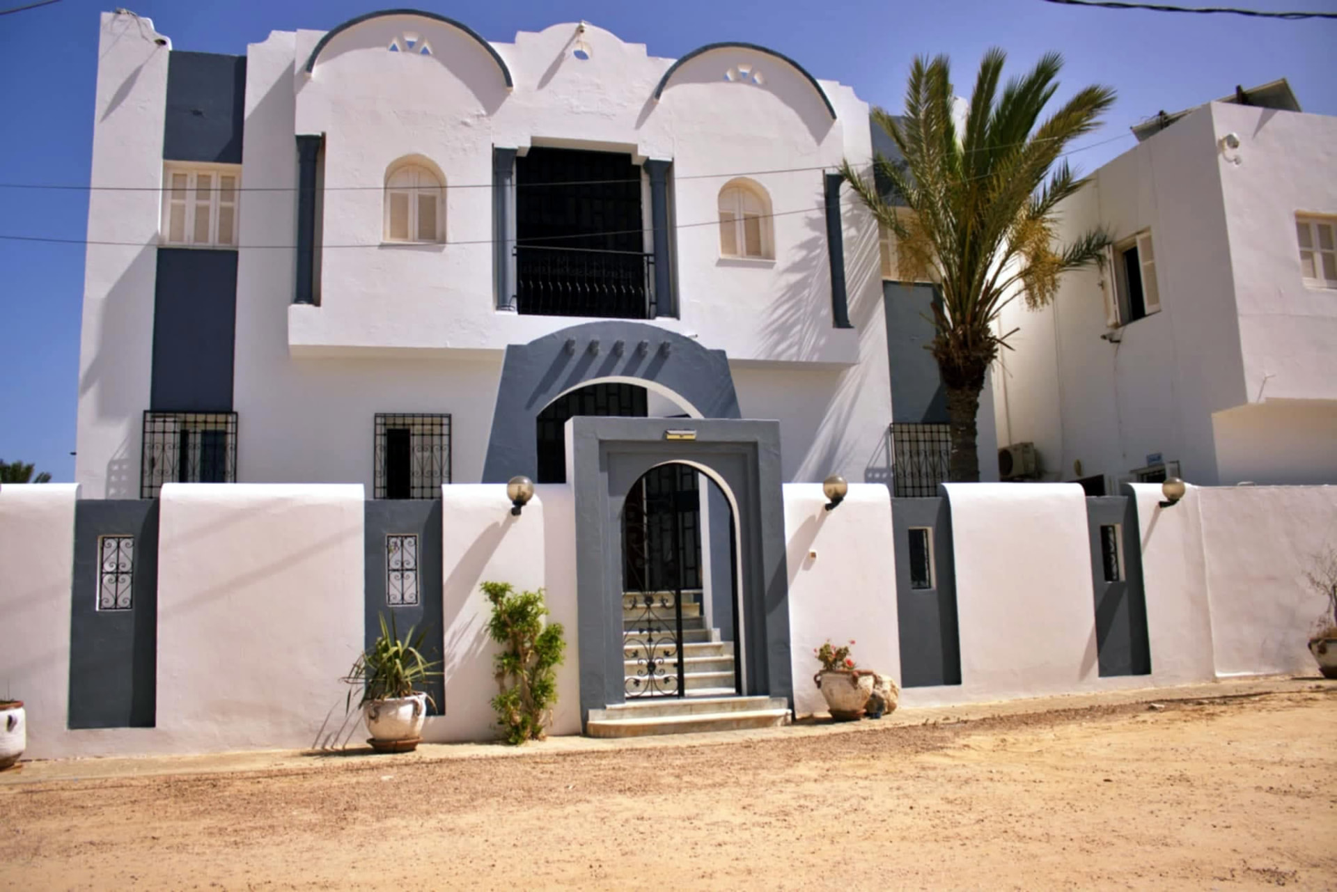 Façade blanche et bleue de la Résidence Les Palmiers Djerba